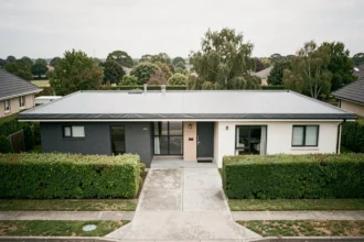 Maison moderne avec un toit à très faible pente recouvert d'une membrane EPDM grise, vue de la rue